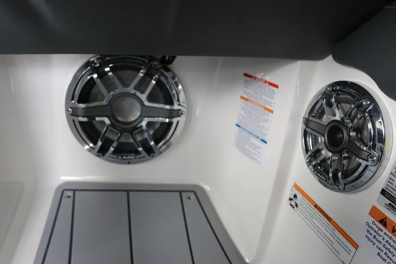 Slide: The Image of 2026 Chaparral 250 OSX boat interior with dual speakers and safety labels. - 39