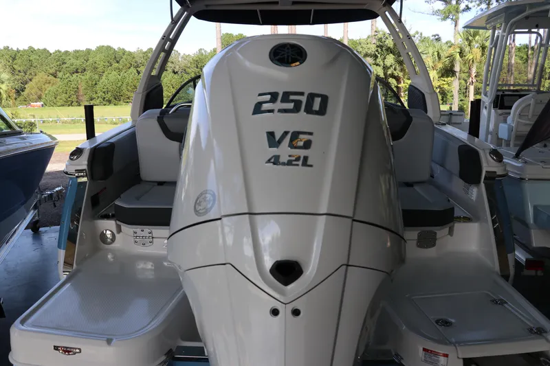 Slide: The Image of 2026 Chaparral 250 OSX boat with V6 4.2L engine, docked outdoors. - 4