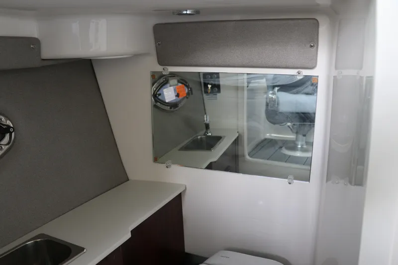 Slide: The Image of 2026 Chaparral 250 OSX cabin interior with sink and mirror. - 50