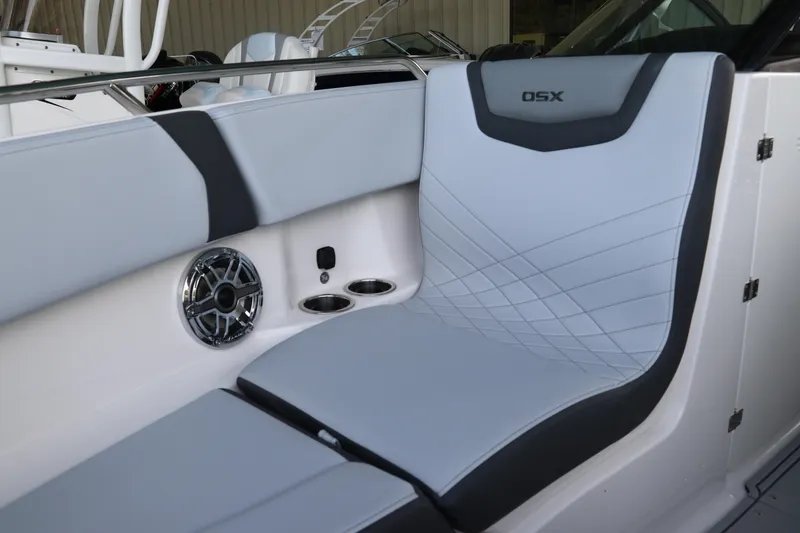 Slide: The Image of 2026 Chaparral 250 OSX boat interior with sleek seating and built-in speaker system. - 54