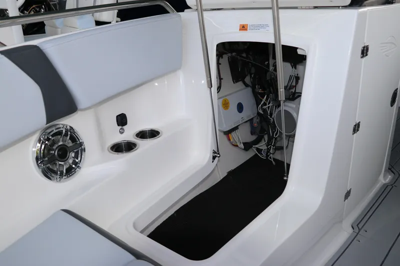 Slide: The Image of 2026 Chaparral 250 OSX boat interior showing storage compartment and speaker system. - 57