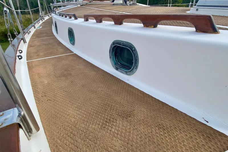 Slide: The Image of 1983 Liberty 38 Cutter deck with portholes and wooden handrails. - 13