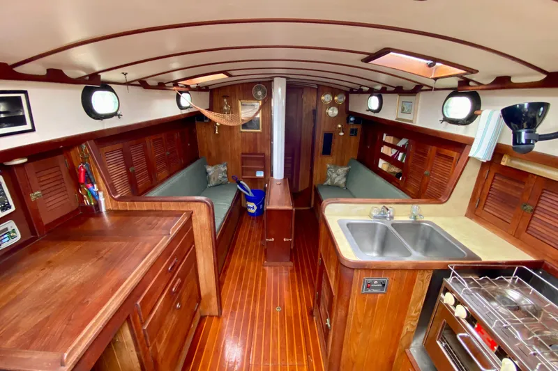 Slide: The Image of Interior of 1983 Liberty 38 Cutter sailboat with wood finish and compact kitchen. - 14
