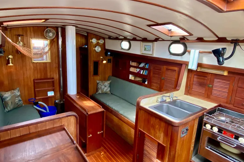 Slide: The Image of Interior of 1983 Liberty 38 Cutter sailboat with wood finish, kitchen, and seating area. - 15