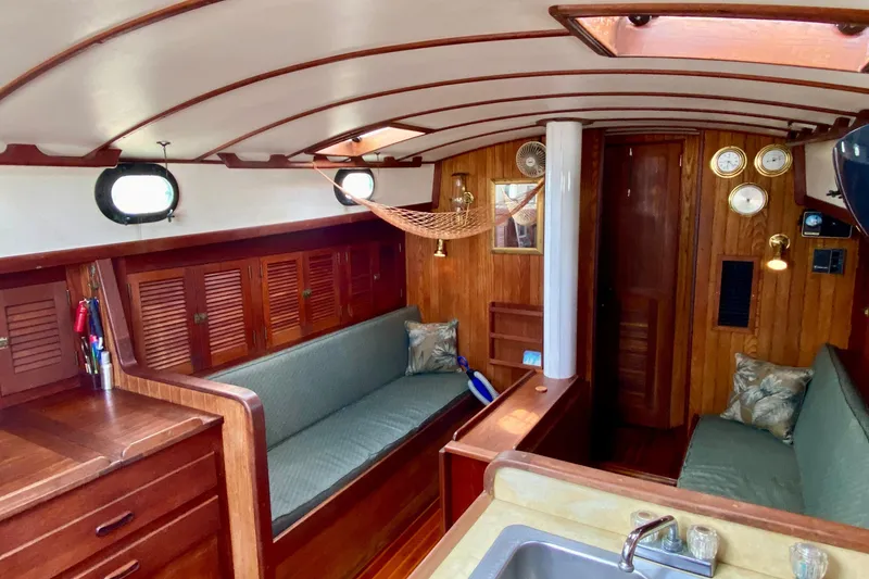 Slide: The Image of Interior of 1983 Liberty 38 Cutter sailboat with wooden furnishings and cozy seating. - 16