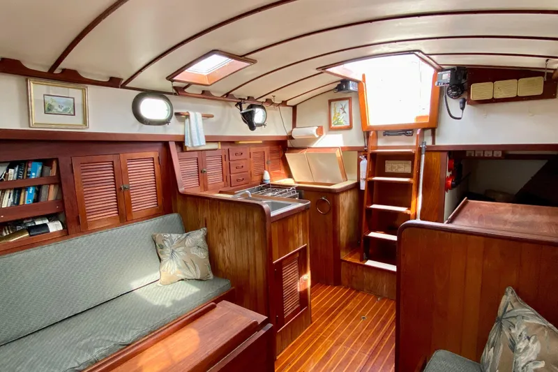 Slide: The Image of Interior of 1983 Liberty 38 Cutter sailboat with wooden furnishings and cozy seating. - 17