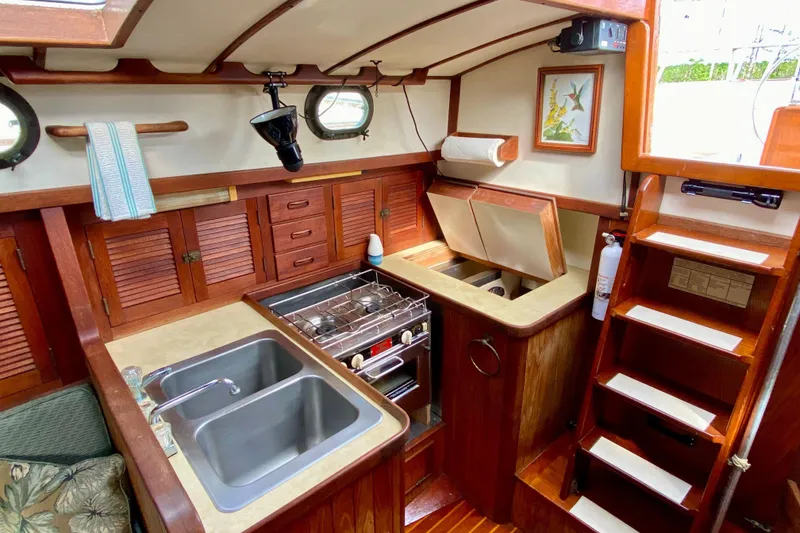 Slide: The Image of Interior of 1983 Liberty 38 Cutter sailboat kitchen with wood cabinetry and dual sinks. - 18
