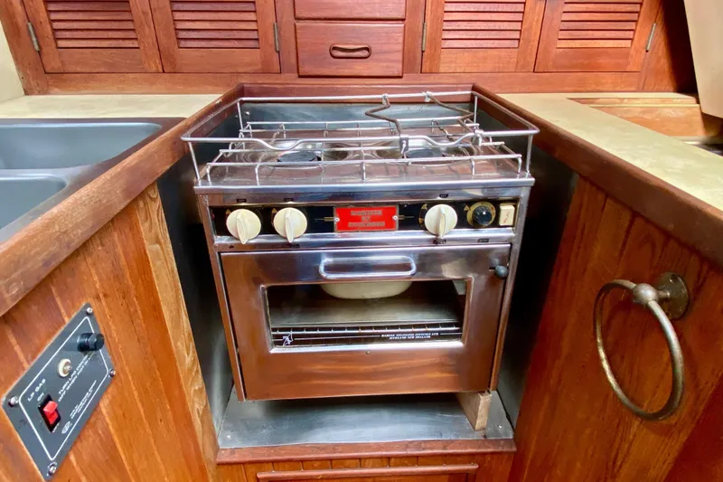 Slide: The Image of Vintage stove in 1983 Liberty 38 Cutter yacht kitchen, featuring wooden cabinetry. - 19