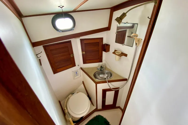 Slide: The Image of Compact bathroom in 1983 Liberty 38 Cutter yacht with sink, toilet, and wooden accents. - 24