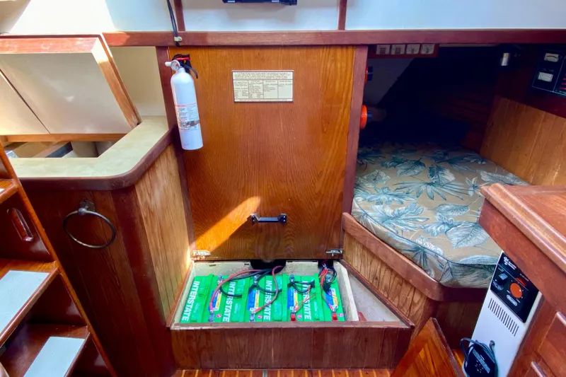 Slide: The Image of Interior of 1983 Liberty 38 Cutter sailboat with open battery compartment and cozy sleeping area. - 25