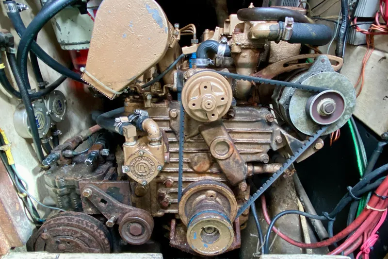 Slide: The Image of Engine of 1983 Liberty 38 Cutter sailboat, showing belts and components in engine compartment. - 27