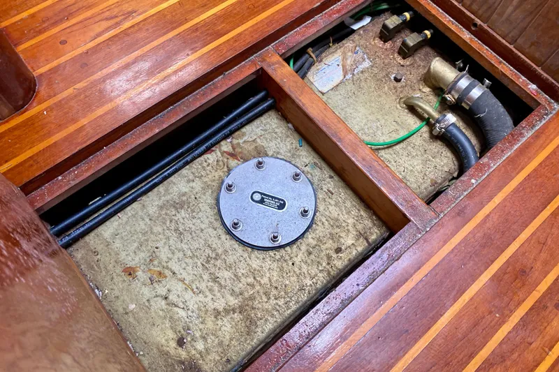 Slide: The Image of 1983 Liberty 38 Cutter interior showing wooden flooring and exposed mechanical components. - 32