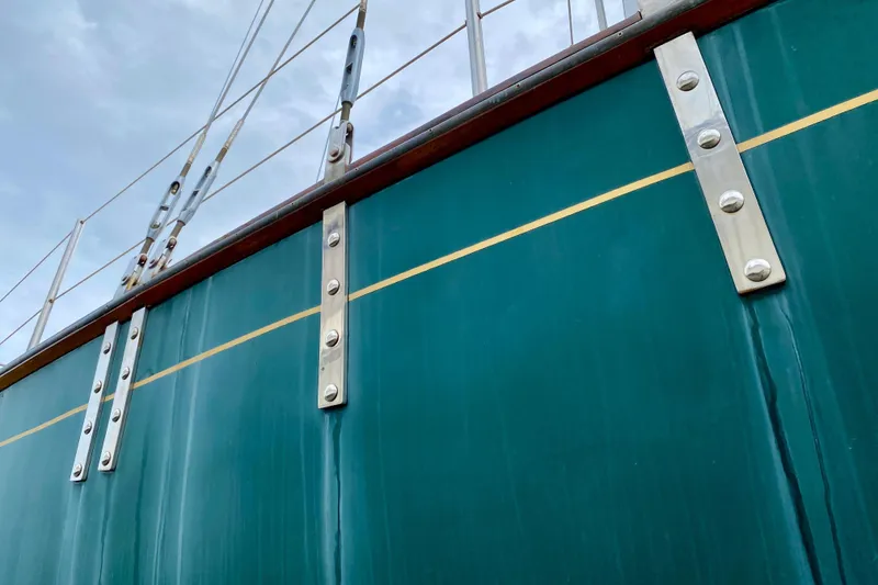 Slide: The Image of Close-up of 1983 Liberty 38 Cutter boat hull with metal fittings and green paint. - 35