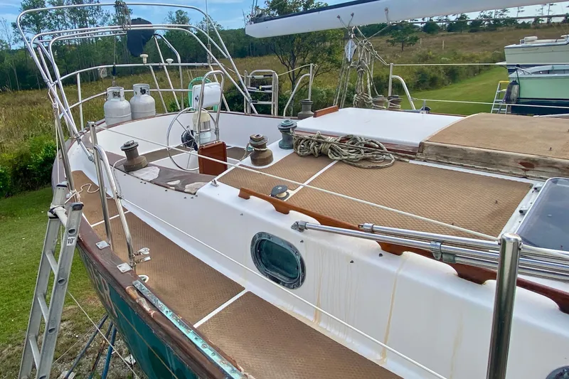 Slide: The Image of 1983 Liberty 38 Cutter sailboat deck with winches, ropes, and propane tanks. - 6
