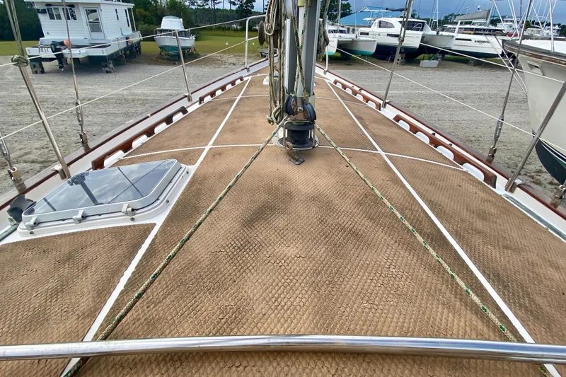 Slide: The Image of 1983 Liberty 38 Cutter sailboat deck with ropes and hatch, docked in a marina. - 7