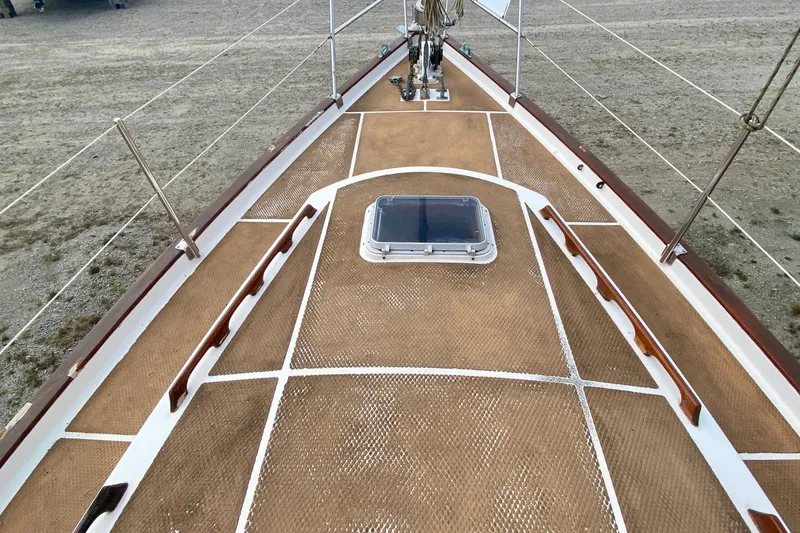 Slide: The Image of Deck view of 1983 Liberty 38 Cutter sailboat, featuring a hatch and wooden handrails. - 8