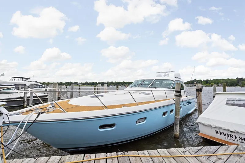 The Image of 2003 Tiara Yachts 5200 Sovran docked at a marina under a partly cloudy sky. - 0