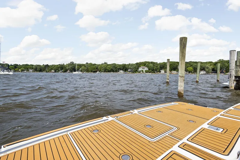 Slide: The Image of 2003 Tiara Yachts 5200 Sovran deck overlooking serene waterfront and docks. - 10