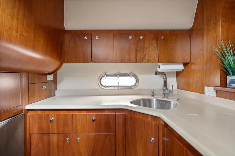 Slide: The Image of Luxurious 2003 Tiara Yachts 5200 Sovran kitchen with wood cabinetry and modern fixtures. - 25