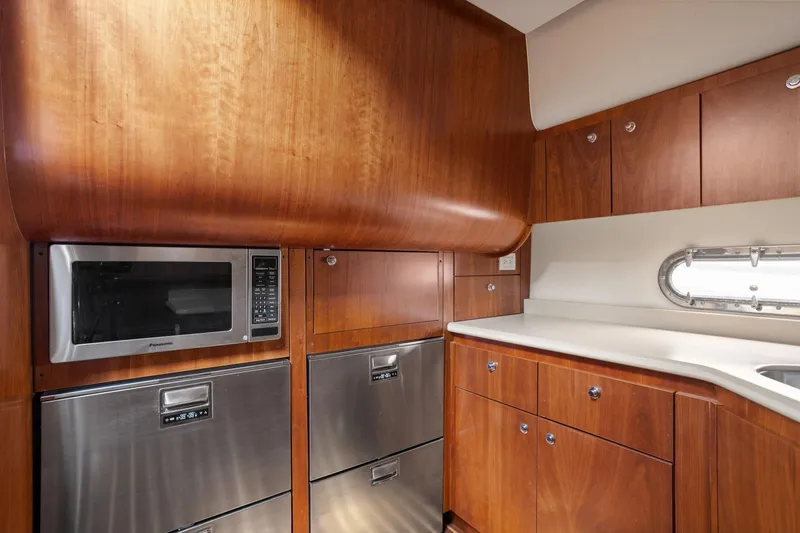 Slide: The Image of Luxurious 2003 Tiara Yachts 5200 Sovran kitchen with wood cabinetry and stainless steel appliances. - 26