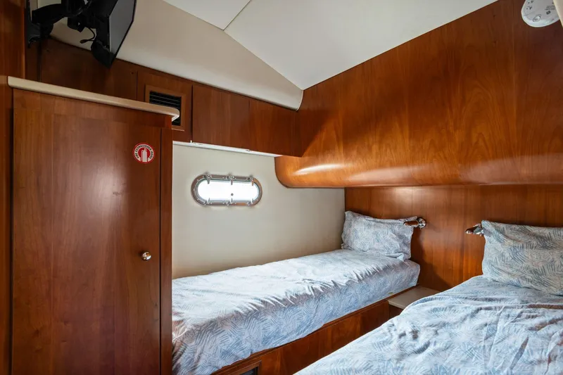 Slide: The Image of 2003 Tiara Yachts 5200 Sovran cabin with twin beds and wooden interior. - 37