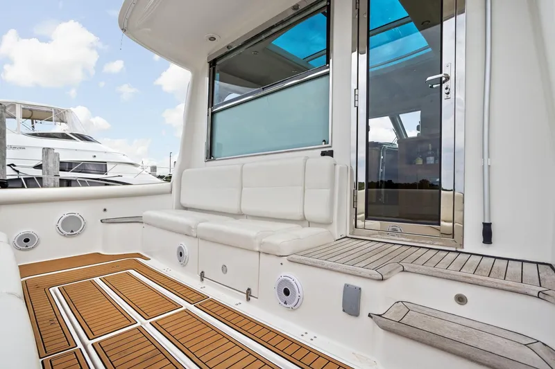 Slide: The Image of 2003 Tiara Yachts 5200 Sovran cockpit with teak flooring and white seating. - 6