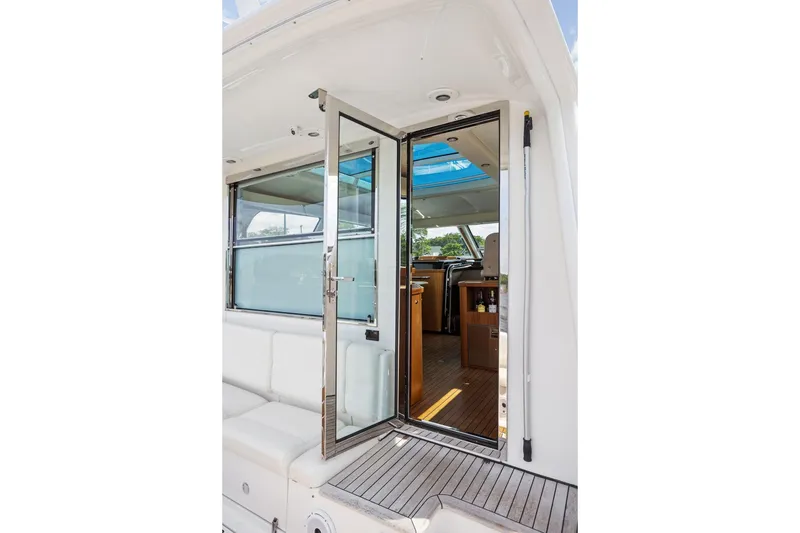 Slide: The Image of 2003 Tiara Yachts 5200 Sovran interior view with open glass door and seating area. - 8
