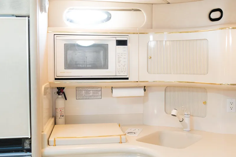 Slide: The Image of Compact kitchen area in 1996 Sea Ray 630 Super Sun Sport yacht with microwave and sink. - 19