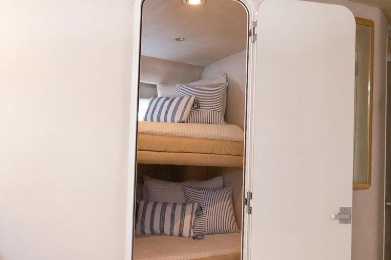 Slide: The Image of Interior of 1996 Sea Ray 630 Super Sun Sport with cozy bunk beds and striped pillows. - 20