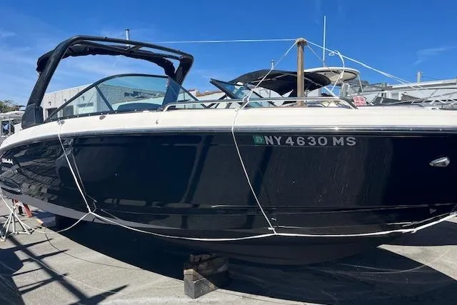 Slide: The Image of 2021 Chaparral 307 SSX boat in dry dock, black hull, sunny day. - 1
