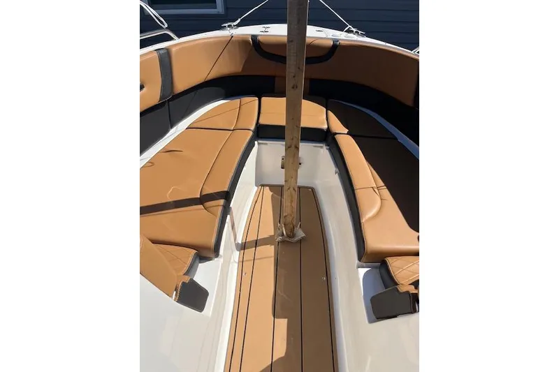 Slide: The Image of 2021 Chaparral 307 SSX boat interior with tan seating and wooden flooring. - 11