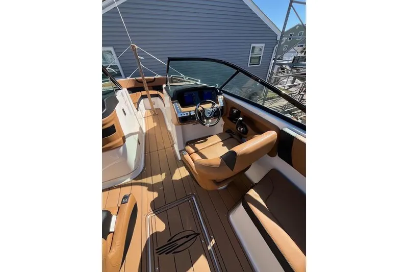 Slide: The Image of 2021 Chaparral 307 SSX boat interior with tan leather seating and modern dashboard. - 7