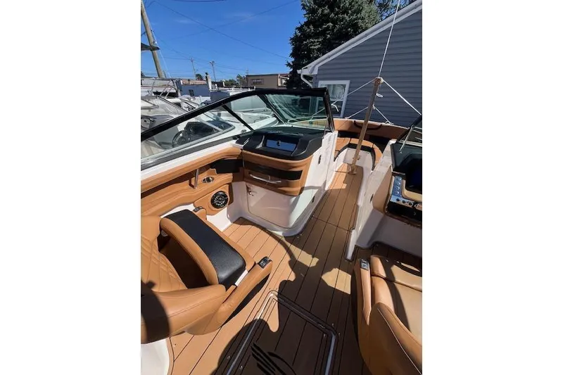 Slide: The Image of 2021 Chaparral 307 SSX boat interior with tan leather seating and modern dashboard. - 8