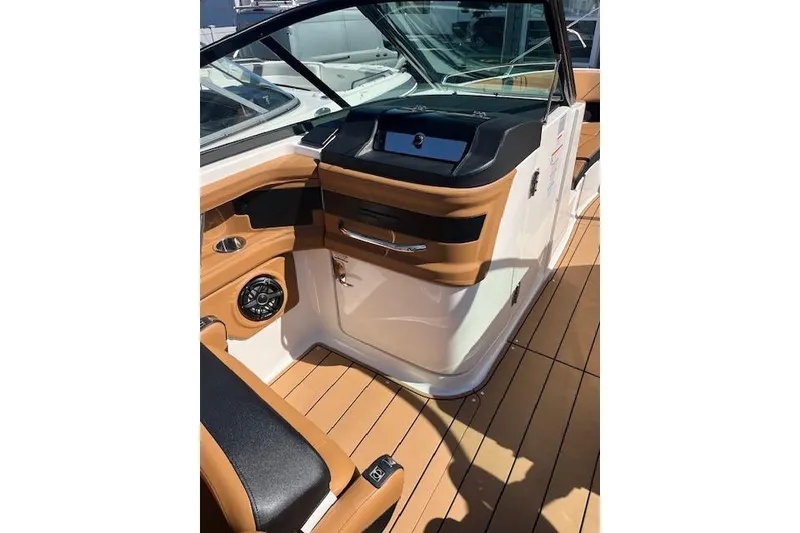 Slide: The Image of 2021 Chaparral 307 SSX boat interior with sleek dashboard and tan accents. - 9