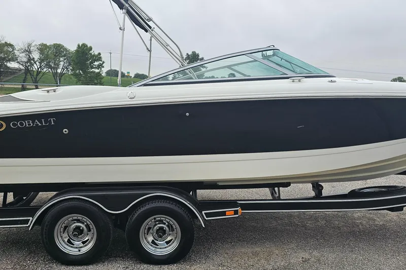 Slide: The Image of 2003 Cobalt 220 boat on trailer, black and white design, parked outdoors. - 1