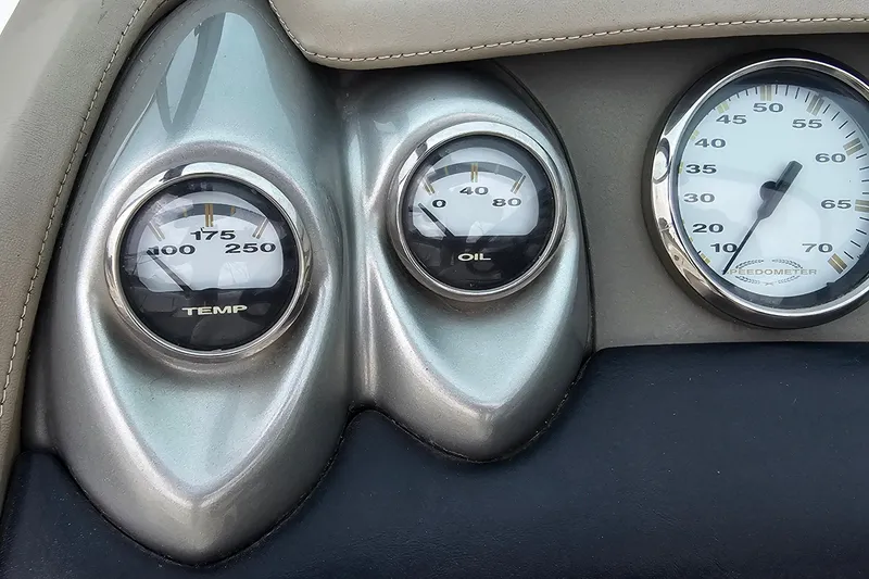 Slide: The Image of Dashboard gauges of a 2003 Cobalt 220 boat, showing temperature, oil, and speedometer. - 13