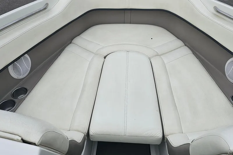 Slide: The Image of Interior of a 2003 Cobalt 220 boat, featuring white cushioned seating and cup holders. - 4