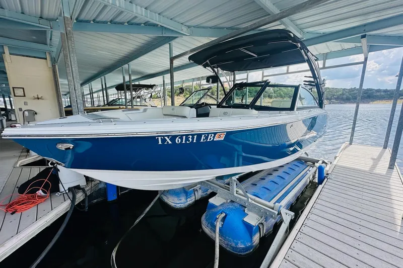 Slide: The Image of 2018 Cobalt CS23 Surf boat docked in a covered marina. - 10