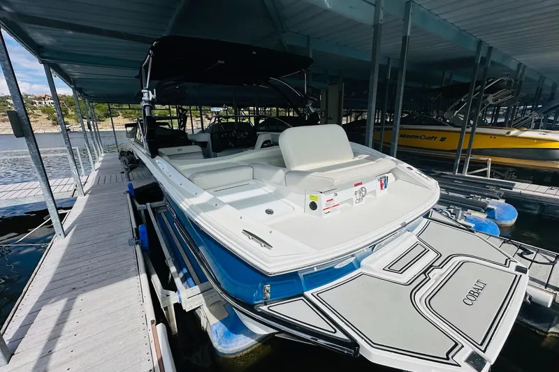 Slide: The Image of 2018 Cobalt CS23 Surf boat docked in a marina under a covered slip. - 12