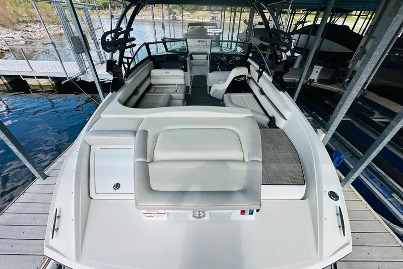 Slide: The Image of 2018 Cobalt CS23 Surf boat docked, featuring spacious seating and modern design. - 13