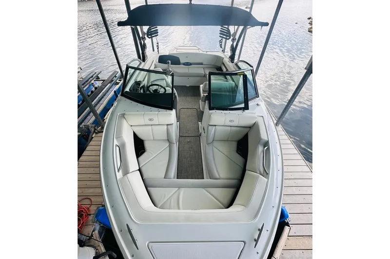 Slide: The Image of 2018 Cobalt CS23 Surf boat with spacious seating and sleek design, docked by the water. - 15