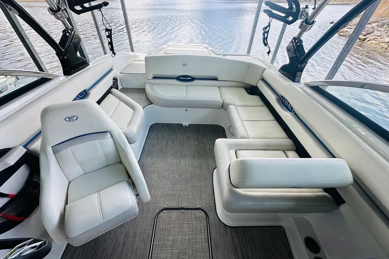 Slide: The Image of 2018 Cobalt CS23 Surf boat interior with white seating and lake view. - 16