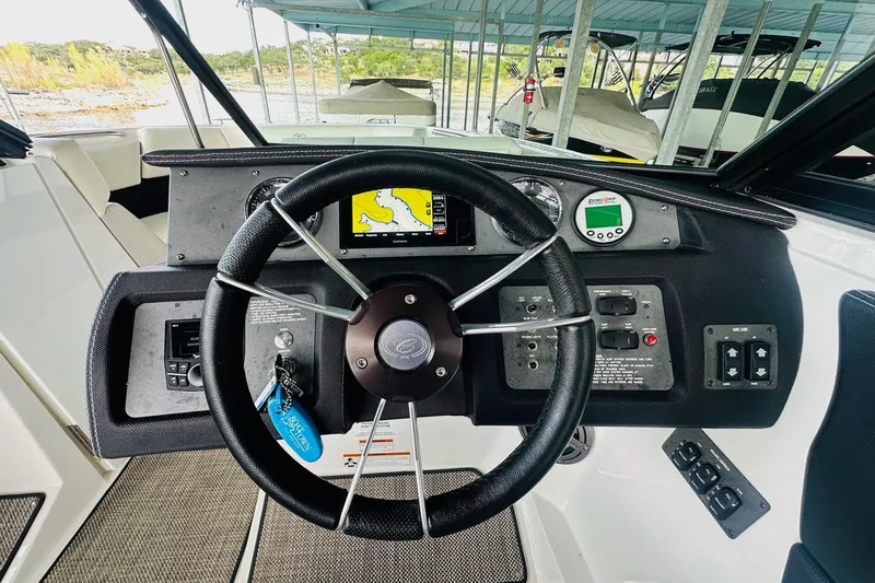 Slide: The Image of Steering wheel and dashboard of 2018 Cobalt CS23 Surf boat in a marina setting. - 21
