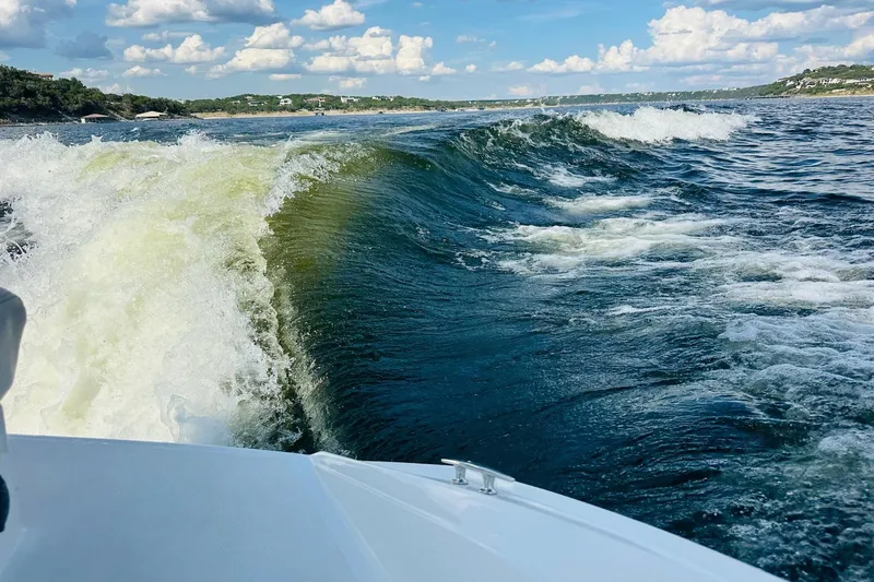 Slide: The Image of 2018 Cobalt CS23 Surf creating waves on a sunny lake day. - 27