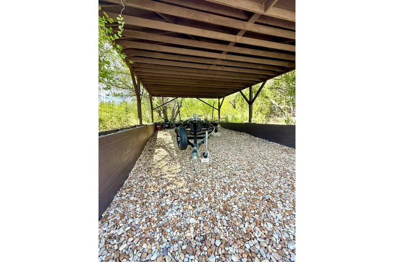 Slide: The Image of Covered storage area with a trailer for a 2018 Cobalt CS23 Surf boat. - 29