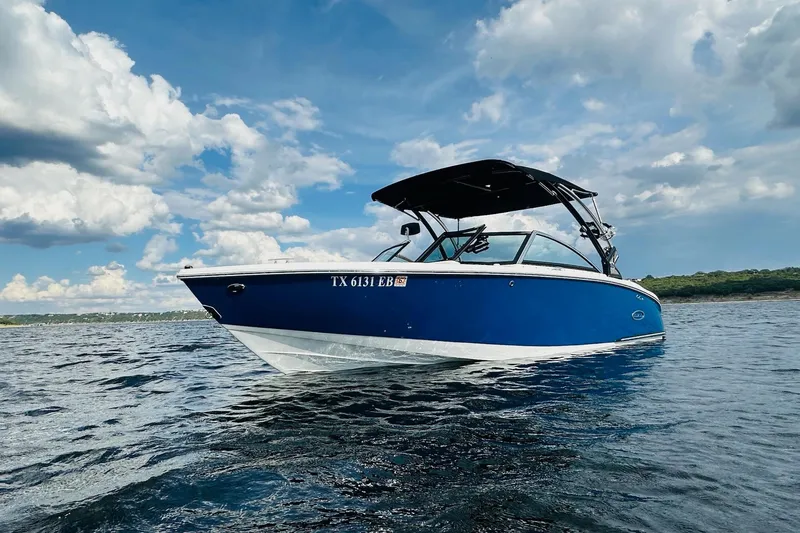 Slide: The Image of 2018 Cobalt CS23 Surf boat on water under a partly cloudy sky. - 3