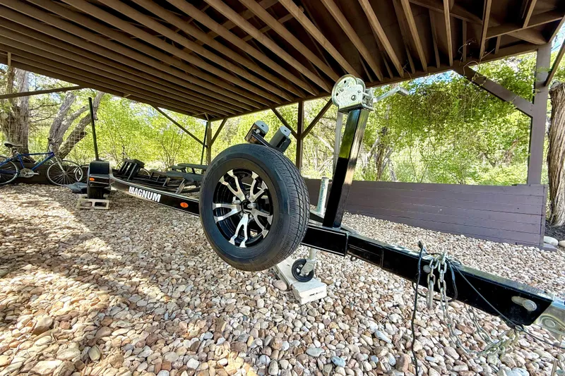 Slide: The Image of Trailer for 2018 Cobalt CS23 Surf boat under a wooden shelter, surrounded by trees. - 30