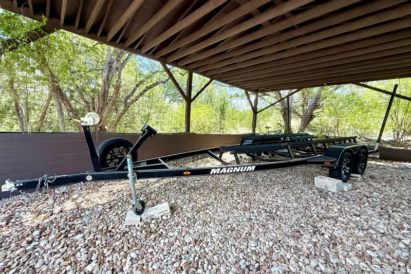 Slide: The Image of Trailer for 2018 Cobalt CS23 Surf boat, parked under a wooden shelter. - 35