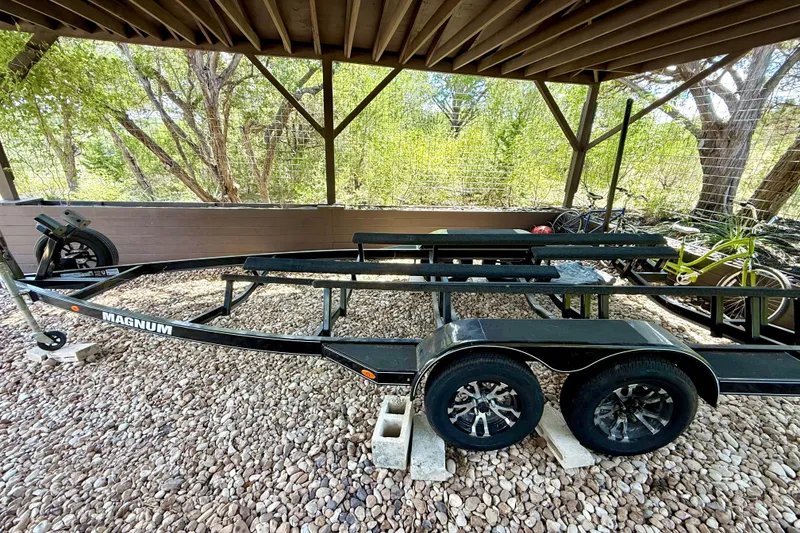 Slide: The Image of Trailer for 2018 Cobalt CS23 Surf boat, parked on gravel under a wooden shelter. - 36