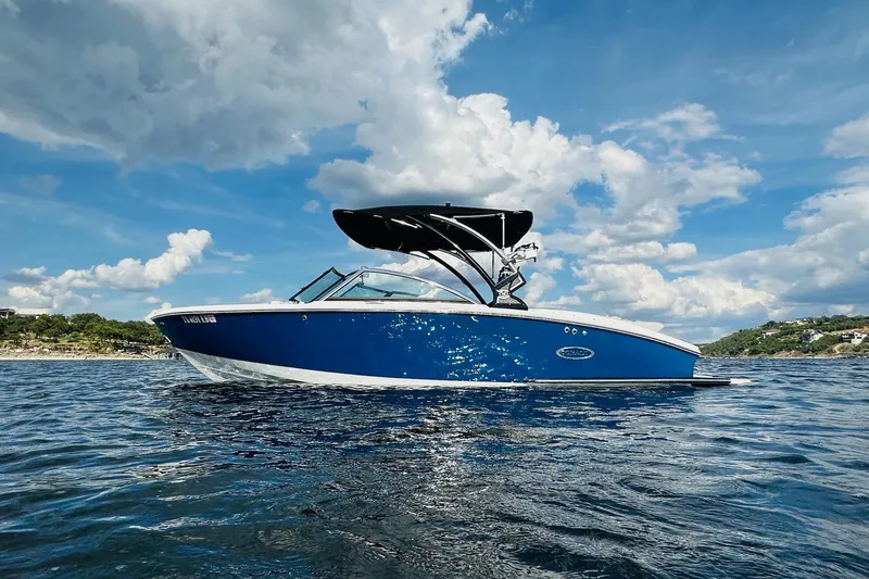 Slide: The Image of 2018 Cobalt CS23 Surf boat on water under blue sky and clouds. - 4